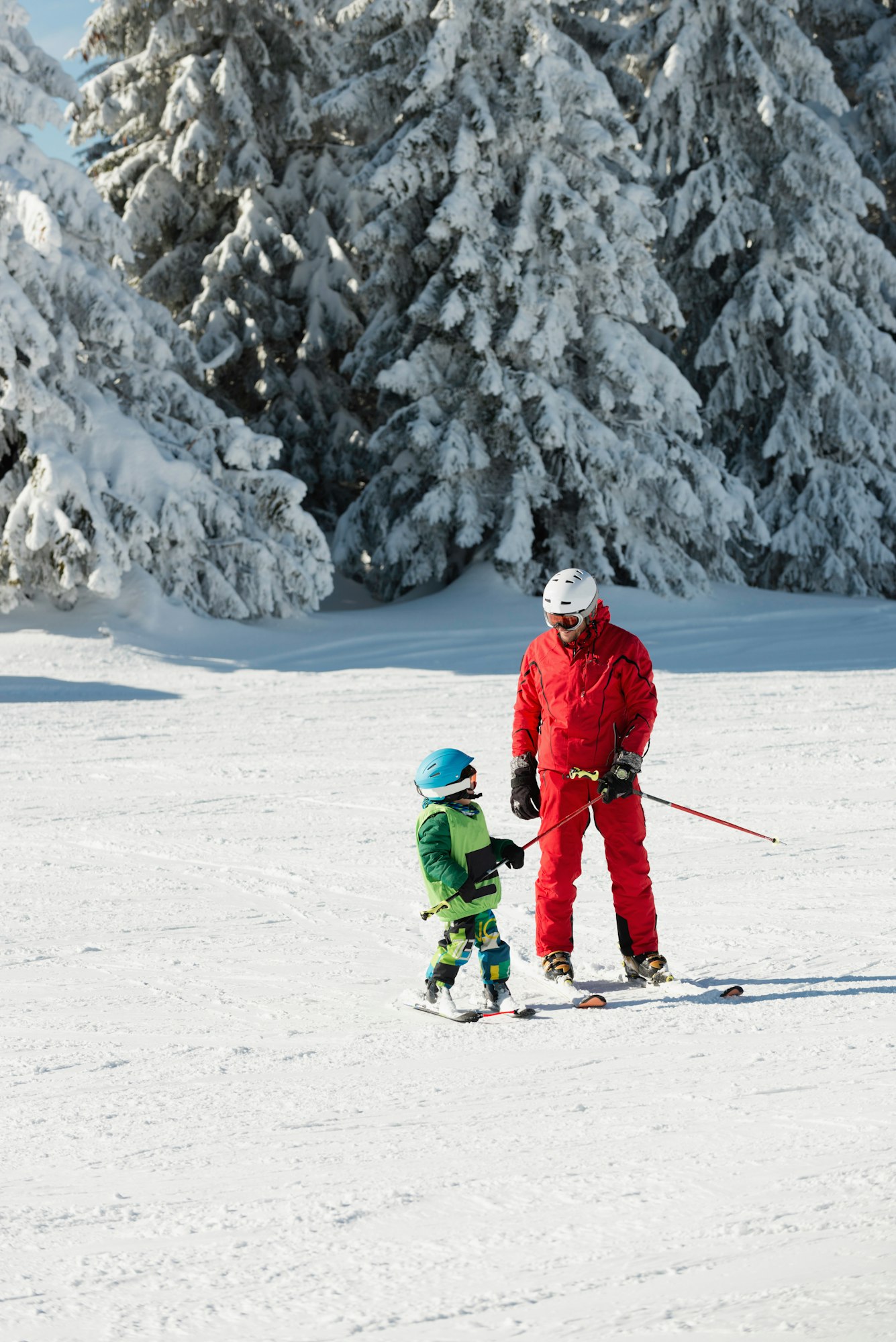 Ski trainer and little boy skiing